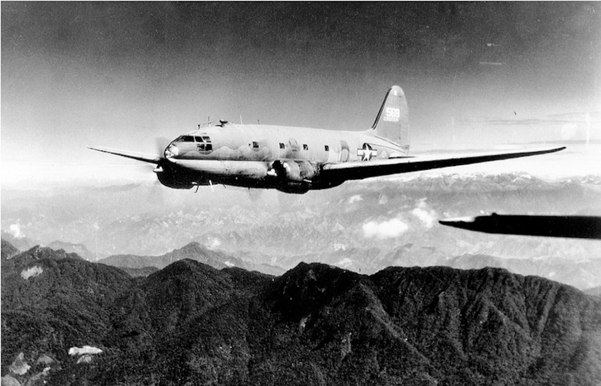 C-46 Commando transport aircraft flies westward over Himalayas