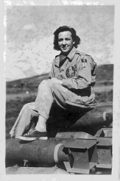Phyllis Dollof sits on a stack of bomb casings.