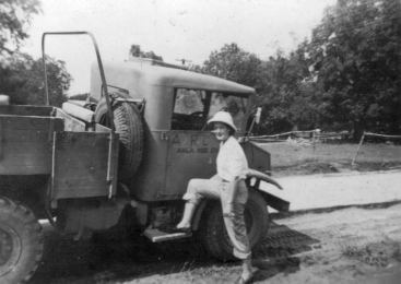 ARC service worker Betty Ringland poses with the recently assigned Red Cross vehicle, an alcohol burning, Russian built truck.